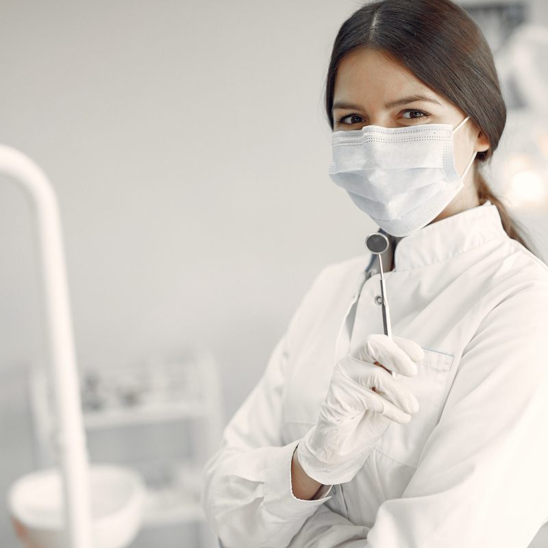 Woman in a uniform. Doctor working at the clinic. Dentist holds a tools in her hands